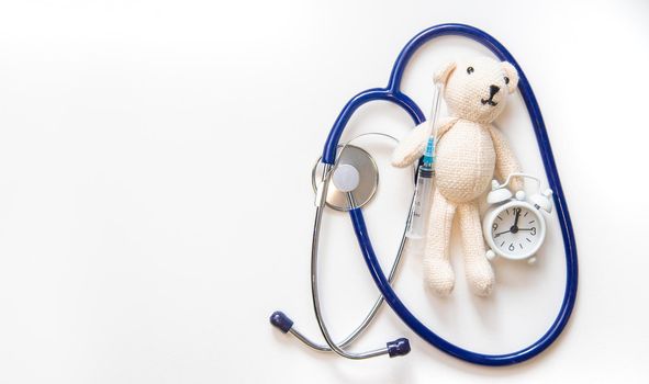 Teddy bear stethoscope and syringe isolate on a white background. Selective focus.