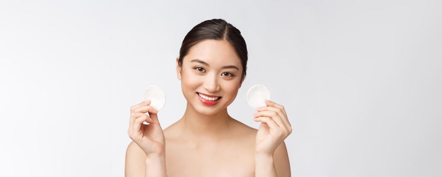 skin care woman removing face makeup with cotton swab pad - skin care concept. Facial closeup of beautiful mixed race model with perfect skin