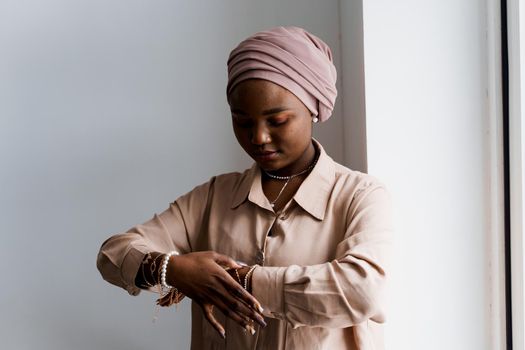 Muslim black girl on white background. African business woman in studio. Model posing. Advert for banking and islamic social media