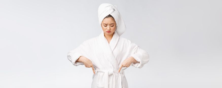 Young beautiful woman wearing shower towel after bath over isolated white background pointing with finger