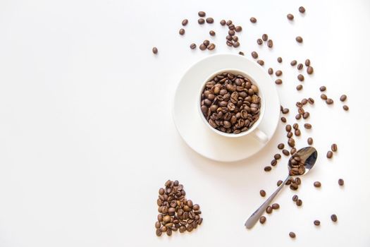 white cup and coffee beans on a white background. Selective focus.