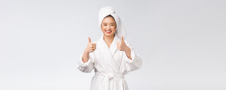 Beautiful asian woman perfect skin showing thumbs up isolated on white background