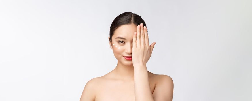 Skin care beauty woman. Beauty woman smiling applying cream. Beauty portrait of beautiful Asian Caucasian female model isolated on white
