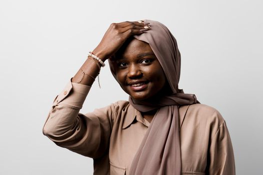 Happy and funny black girl on white background. Young muslim woman smiling in studio. Advert for social network.