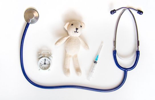 Teddy bear stethoscope and syringe isolate on a white background. Selective focus.