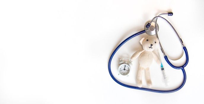 Teddy bear stethoscope and syringe isolate on a white background. Selective focus.