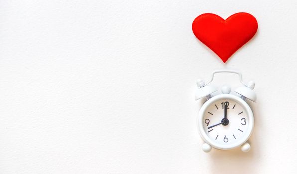 alarm clock with a heart on a white background. Selective focus.