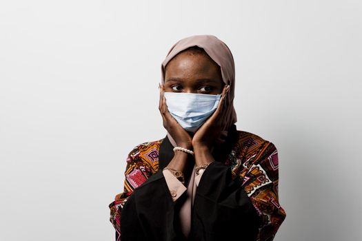 Black muslim business woman in medical mask weared in hijab on white backgroud. Cryptocurrency investments in bitcoin. Successful black girl.