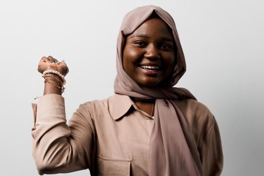 Happy and funny black girl on white background. Young muslim woman smiling in studio. Advert for social network.