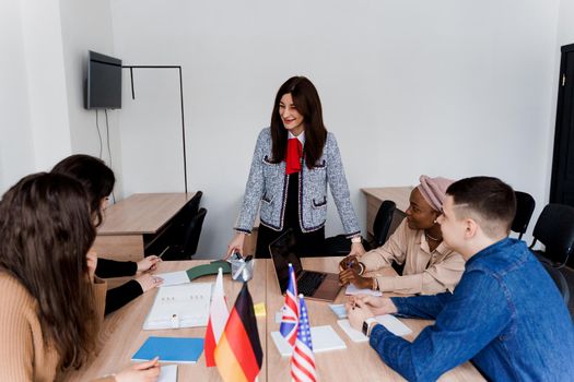 Teamwork. Working in multiethnic group of students. teacher study foreign languages together in class. Studing with laptop. Black handsome girl student study with white people together