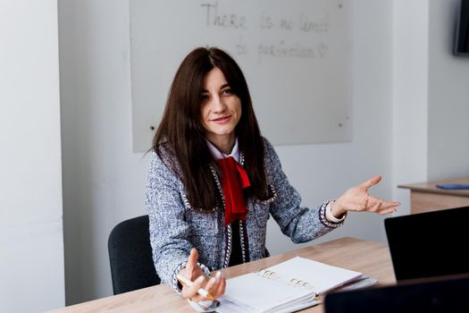 Attractive girl teacher explain rules in english class. Education in university. Foreign school private study with a school girl. Teacher explain grammar of native language using laptop.