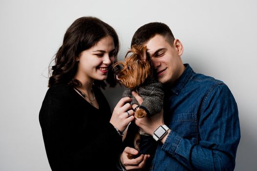Yorkshire terrier with lovely couple on white background. Happy family with dog. Love to pets.