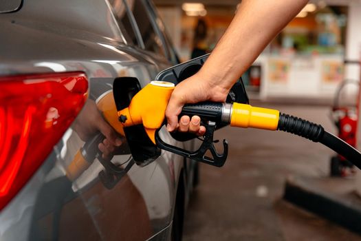 Hand Man Refill and filling Oil Gas Fuel at station. Gun petrol in the tank to fill. Pumping gasoline fuel in car at gas station. Refueling automobile with gasoline or diesel with a fuel dispenser. Fuel business