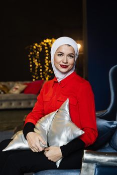 Muslim woman near christmas decoration in studio. Professional muslim model posing at the new year eve.