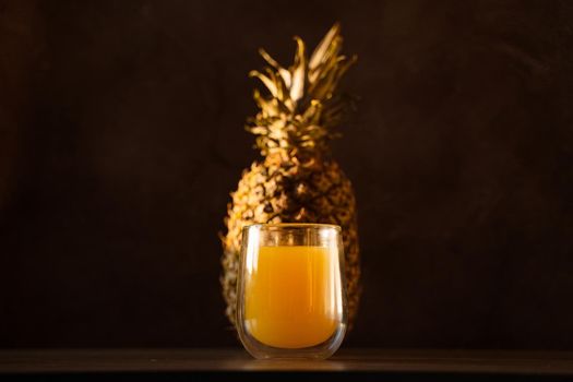 Pineapple fruit and juice in double glass cup. Tropical fruit . Pouring yellow tropical juice into glass.