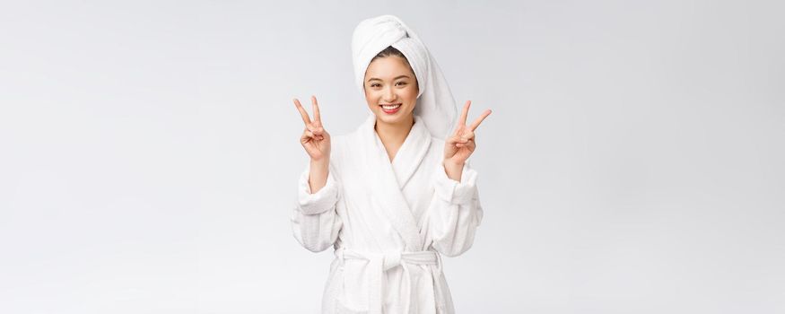 Beautiful asian woman showing peace sign or two finger with happy feeling. Isolated over white background