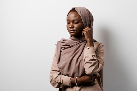 Muslim black girl on white background. African business woman in studio. Model posing. Advert for banking and islamic social media