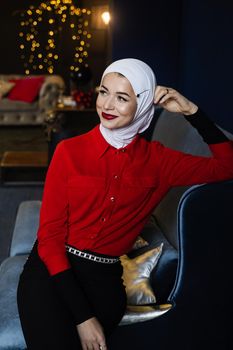Muslim woman near christmas decoration in studio. Professional muslim model posing at the new year eve.