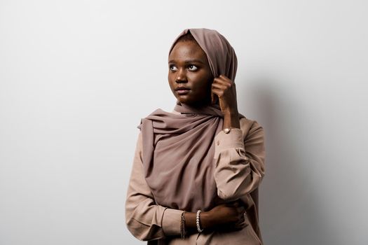 Muslim black girl on white background. African business woman in studio. Model posing. Advert for banking and islamic social media