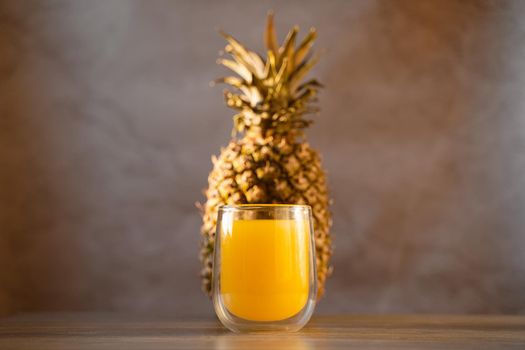 Pineapple fruit and juice in double glass cup. Tropical fruit . Pouring yellow tropical juice into glass.