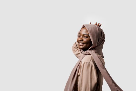 Happy and funny black girl on white background. Young muslim woman smiling in studio. Advert for social network.