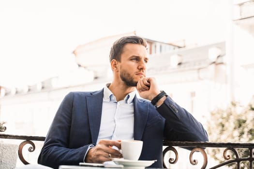 Handsome man with cup of coffee in cafe. Morning lifestyle of male