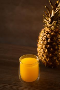 Pineapple fruit and juice in double glass cup. Tropical fruit . Pouring yellow tropical juice into glass.