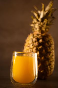 Pineapple fruit and juice in double glass cup. Tropical fruit . Pouring yellow tropical juice into glass.