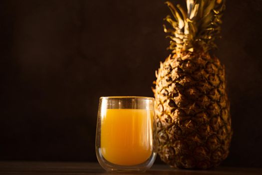 Pineapple fruit and juice in double glass cup. Tropical fruit . Pouring yellow tropical juice into glass.