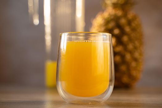 Pineapple fruit and juice in double glass cup. Tropical fruit . Pouring yellow tropical juice into glass.