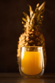 Pineapple fruit and juice in double glass cup. Tropical fruit . Pouring yellow tropical juice into glass.