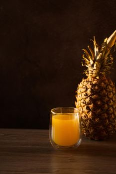 Pineapple fruit and juice in double glass cup. Tropical fruit . Pouring yellow tropical juice into glass.