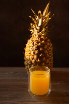 Pineapple fruit and juice in double glass cup. Tropical fruit . Pouring yellow tropical juice into glass.