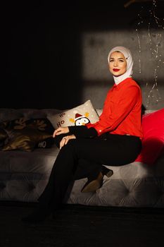 Muslim woman near christmas lights and decoration in studio. Professional muslim model posing at the new year eve.