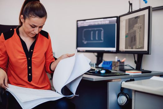 Within the heavy industry, a factory industrial engineer measures with a caliper and on a personal computer Designs a 3D model. High quality photo