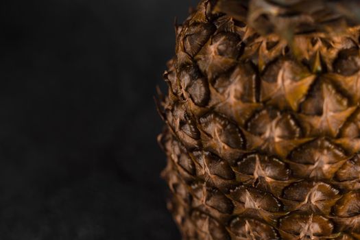 Close-up pineapple tropical fruit on dark stone background background. Citrus fruit with vitamin c for helth care
