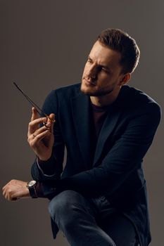 Doctor with surgical equipment needle and scissors. Handsome man weared casual business suit. Portrait of surgeon in studio