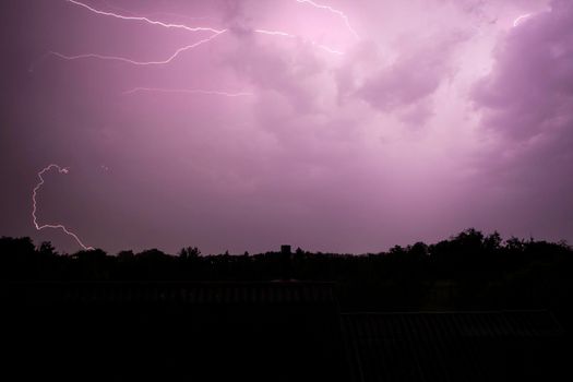 Lightning streak from a thunderstorm cloud at night. Multiple lightning strikes coming from the thunderstorm.