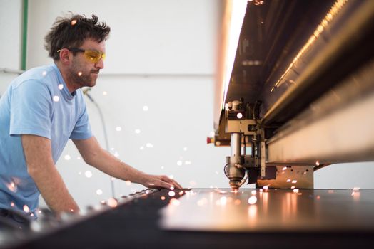 Within heavy industry. A man works in a modern factory on a CNC machine. Selective focus. High-quality photo