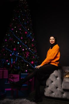 Muslim woman in black hijab near new year tree waiting for celebration of Christmas. Islam religion