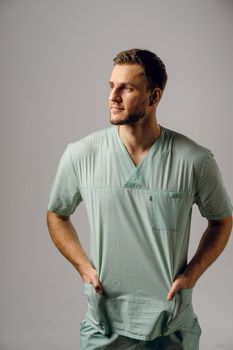 Surgeon weared in medical robe smile and posing on white background. Handsome happy doctor posing in studio