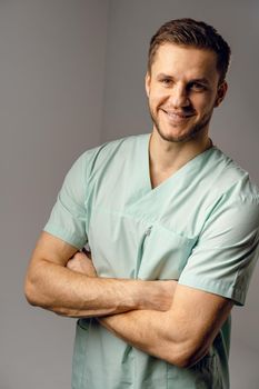 Surgeon weared in medical robe smile and posing on white background. Handsome happy doctor posing in studio