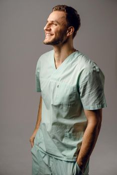 Surgeon weared in medical robe smile and posing on white background. Handsome happy doctor posing in studio