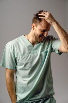 Surgeon weared in medical robe smile and posing on white background. Handsome happy doctor posing in studio