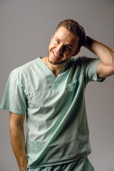 Surgeon weared in medical robe smile and posing on white background. Handsome happy doctor posing in studio