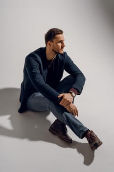 Fashion business man model posing in the studio. Confident male weared casual suit.