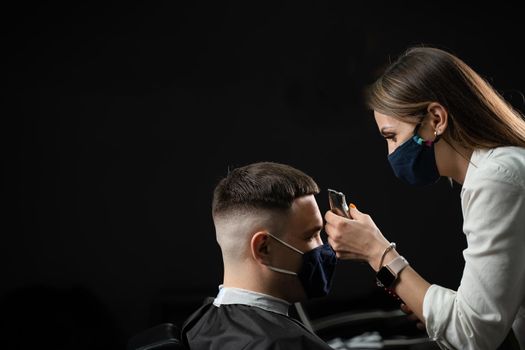 Barbershop customer in medical mask for protection against coronavirus covid-19. Making hairstyle for handsome man