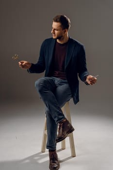 Handsome surgeon with needle holder and surgical knife weared casual suit in studio. Confident business man on dark background