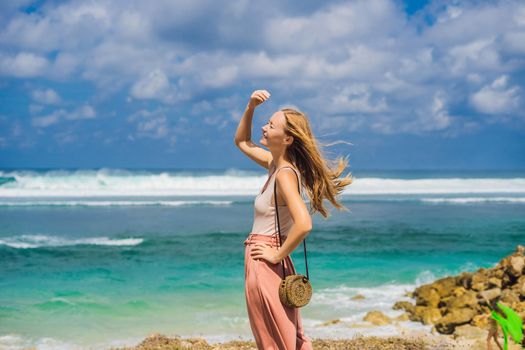 Young woman traveler on amazing Melasti Beach with turquoise water, Bali Island Indonesia.