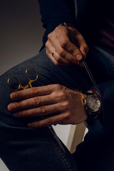 Needle holder and surgical knife and business watch close-up.